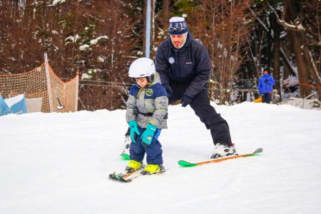 señor grande y niño esquiando en bautismo de nieve en ushuaia